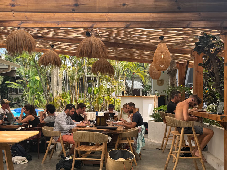 Personnes travaillant dans un espace de coworking extérieur tropical.